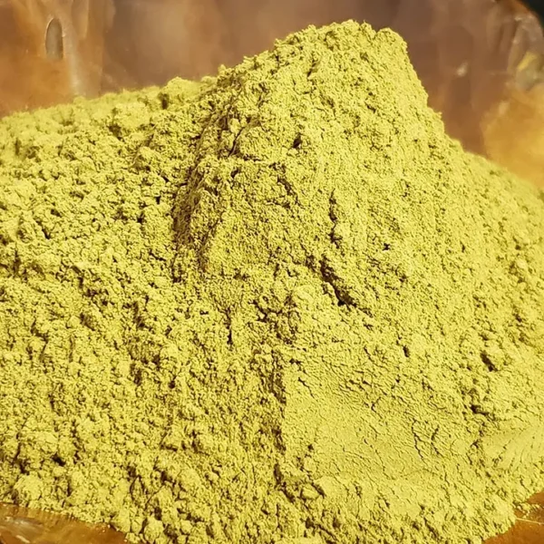 Yellow Kratom Powder elegantly presented in a wooden leaf-shaped dish, highlighting its natural color and fine texture.